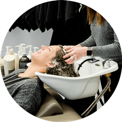 hair stylist washing females hair in salon